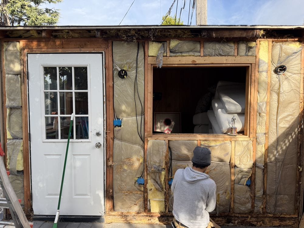 Exterior wall opened to the framing for rot and structural repair before new siding