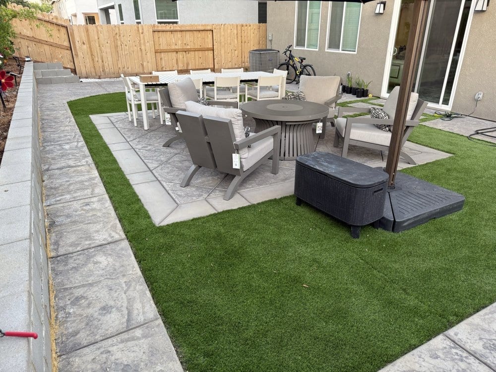 Finished backyard with stamped concrete patio, artificial turf and new fencing