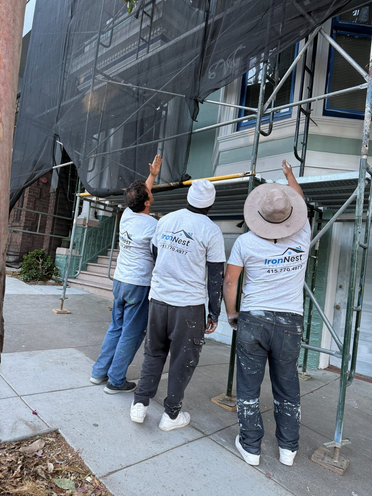 IronNest crew on scaffolding with containment netting during a Victorian exterior repaint in San Francisco